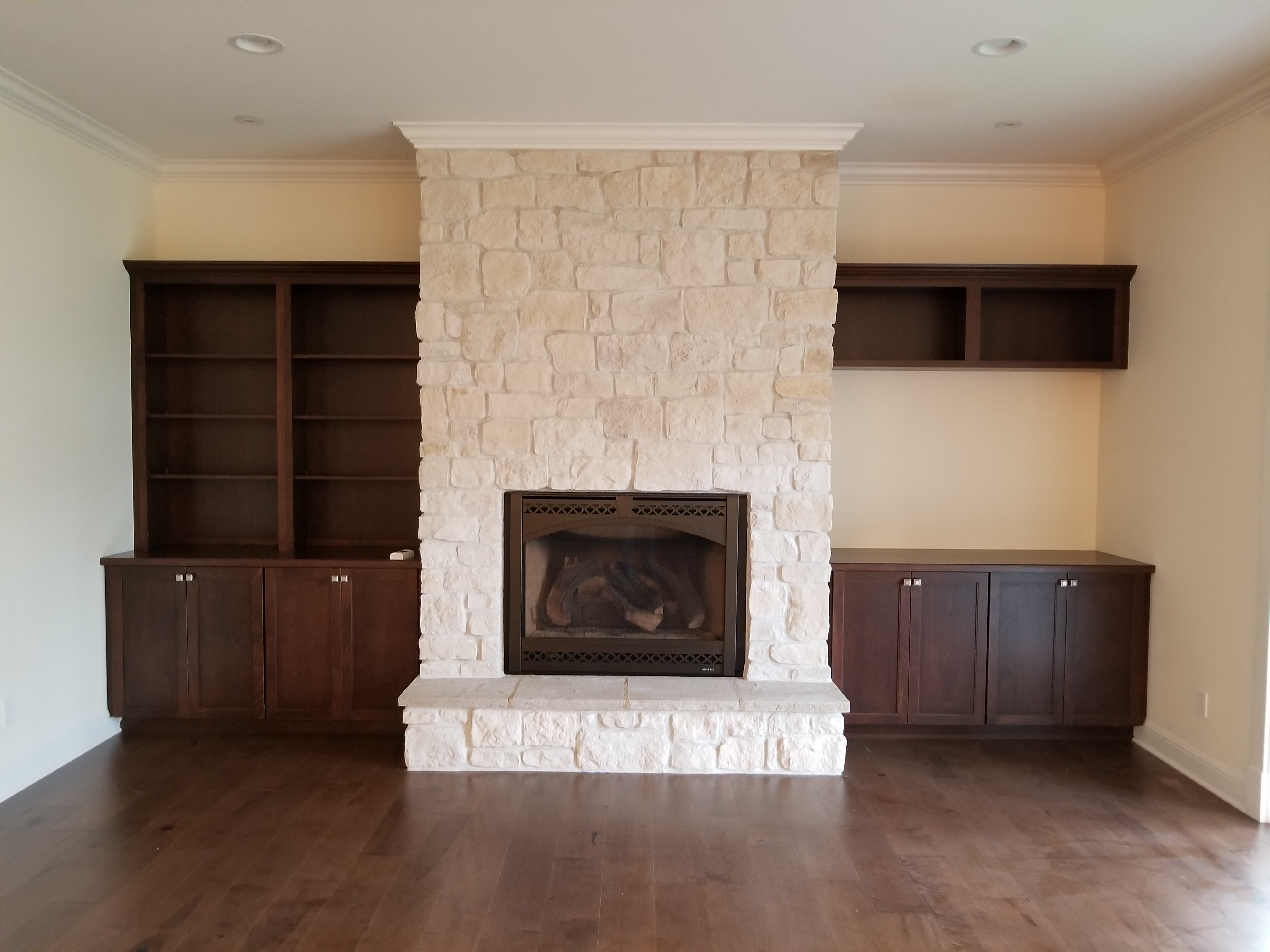 Interior white stone fireplace with custom built-in cabinetry